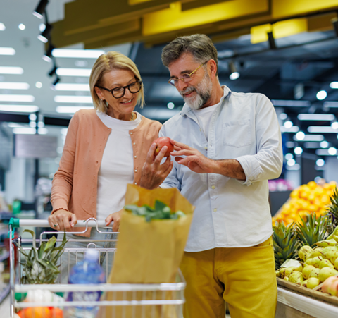 couple shopping for apples in grocery store
